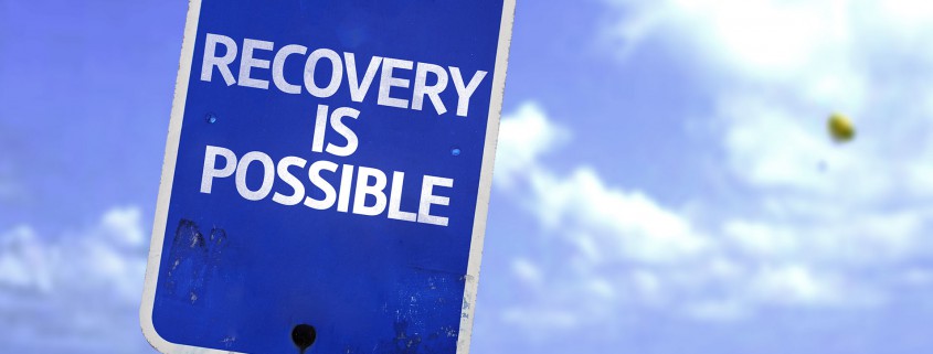 Recovery is Possible sign with a beach on background